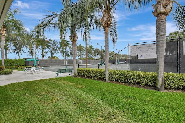 view of tennis court featuring a yard