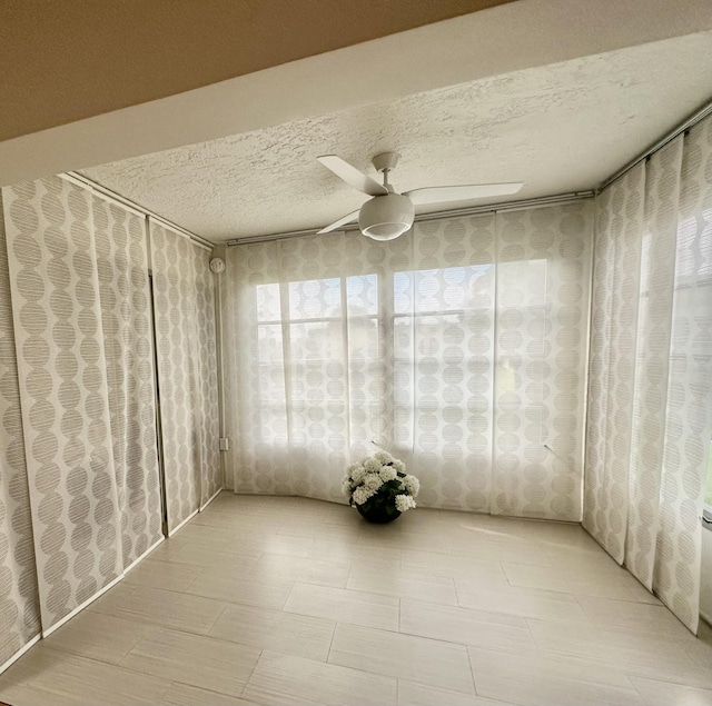 spare room with ceiling fan and a textured ceiling