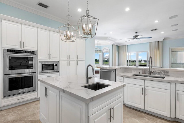 kitchen featuring white cabinetry, sink, appliances with stainless steel finishes, and an island with sink