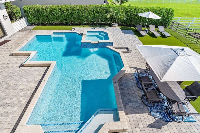 view of pool featuring an in ground hot tub, a patio, and a lawn