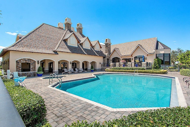 view of pool featuring a patio and exterior fireplace