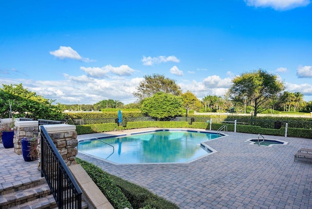 view of pool featuring a patio area and an in ground hot tub