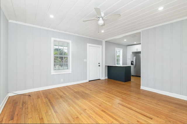 unfurnished living room featuring ceiling fan, crown molding, and light hardwood / wood-style flooring