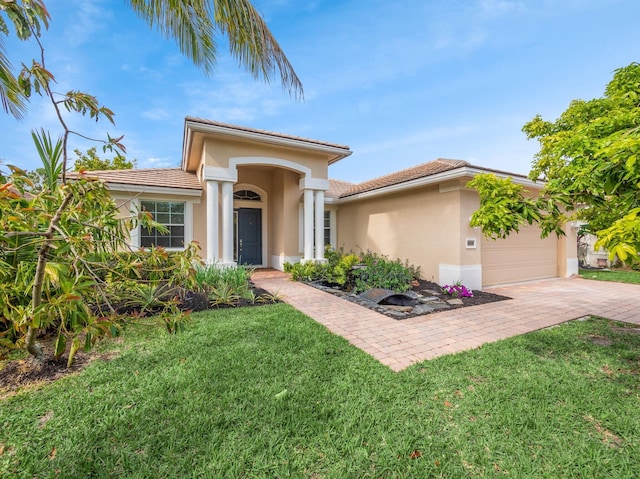 view of front of home with an attached garage, a front lawn, decorative driveway, and stucco siding