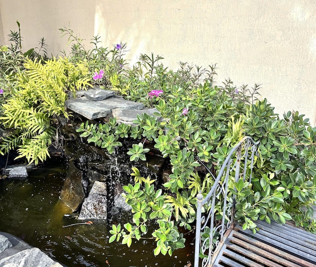 details with a garden pond and stucco siding