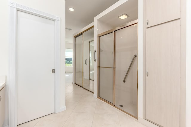 bathroom with tile patterned flooring, an enclosed shower, and toilet