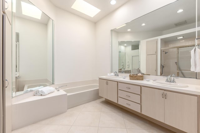 bathroom featuring tile patterned flooring, vanity, a skylight, and plus walk in shower