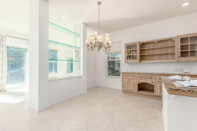 kitchen with pendant lighting, light tile patterned flooring, a wealth of natural light, and an inviting chandelier