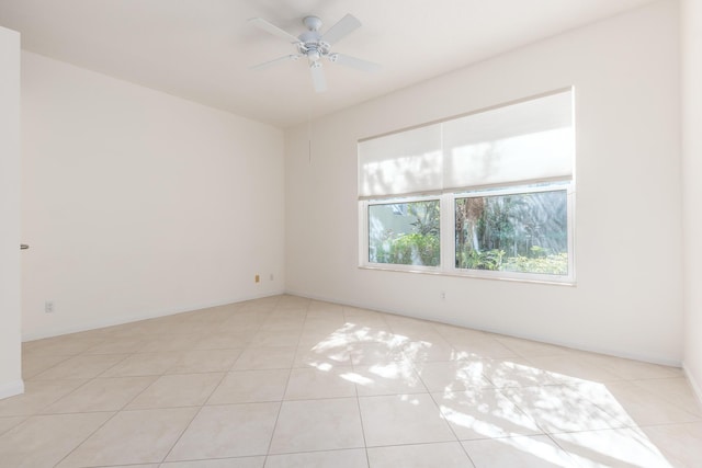 spare room with ceiling fan and light tile patterned floors