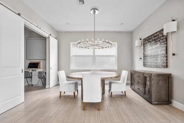 dining area featuring a barn door and a notable chandelier