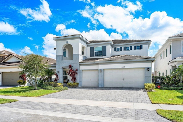 mediterranean / spanish house featuring a garage and a front yard