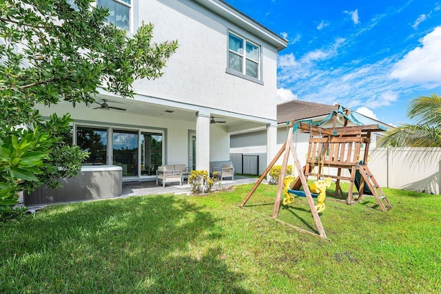 rear view of property with a yard, a patio, a playground, and ceiling fan