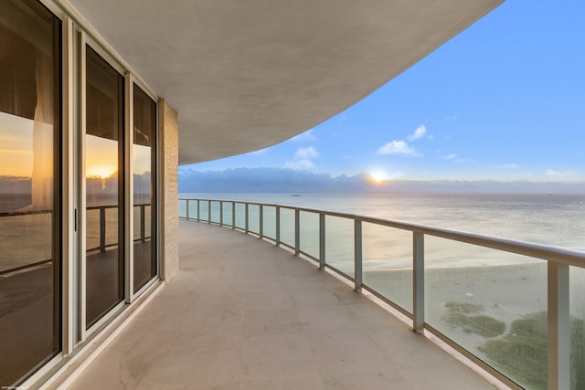 balcony featuring a water view and a beach view