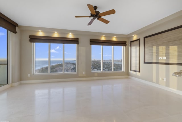 spare room with ceiling fan and light tile patterned floors