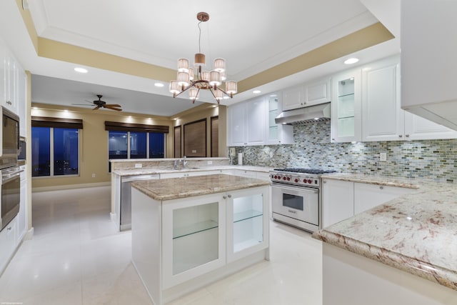 kitchen featuring appliances with stainless steel finishes, backsplash, ceiling fan with notable chandelier, decorative light fixtures, and white cabinets