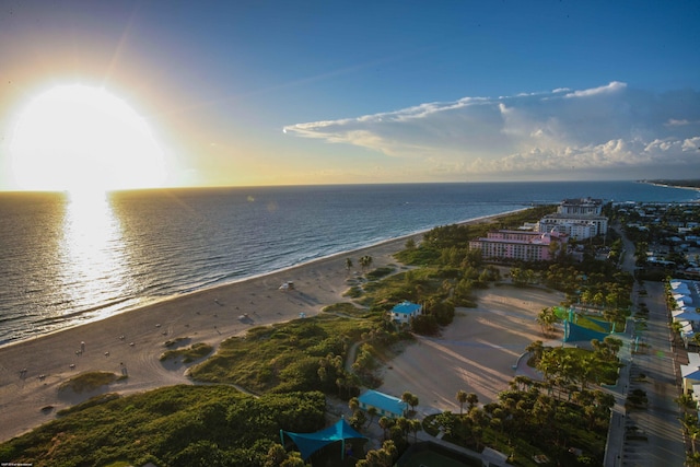 aerial view at dusk with a beach view and a water view