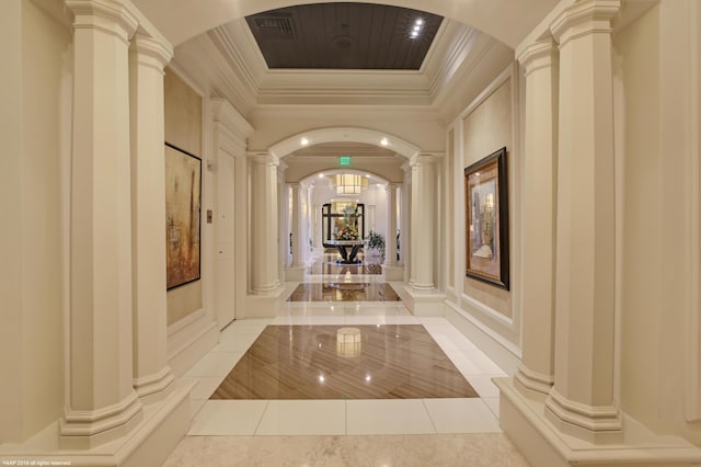 corridor featuring ornamental molding, light tile patterned floors, and decorative columns