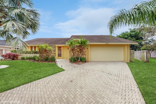 single story home featuring a garage and a front lawn