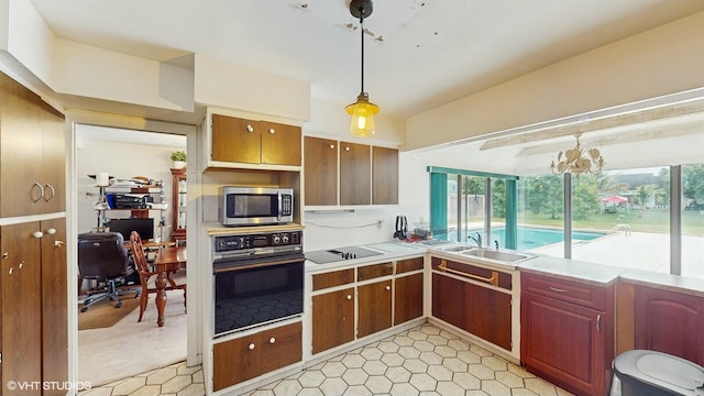 kitchen with sink, pendant lighting, and black appliances