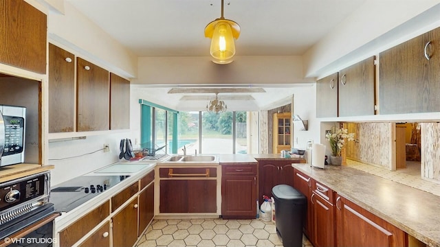 kitchen featuring hanging light fixtures, sink, and black appliances