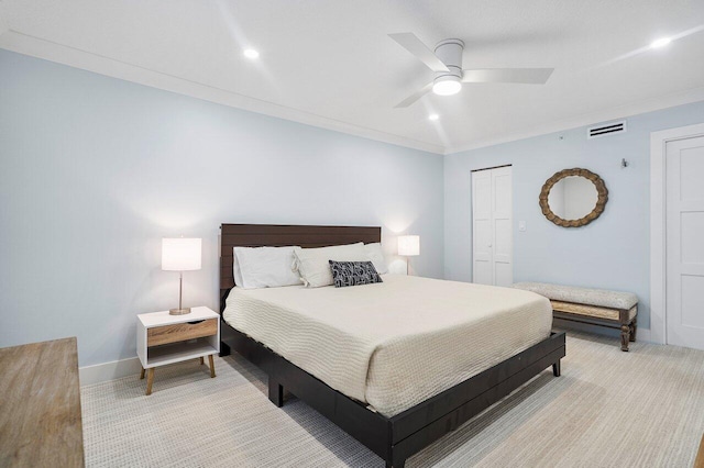 bedroom featuring ceiling fan, light colored carpet, crown molding, and a closet