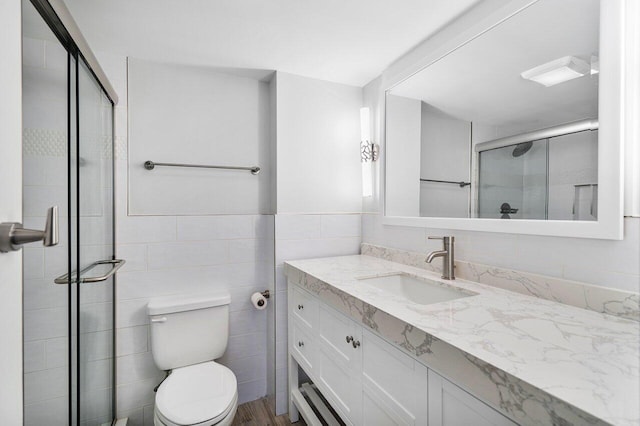 bathroom featuring hardwood / wood-style floors, vanity, toilet, and a shower with shower door