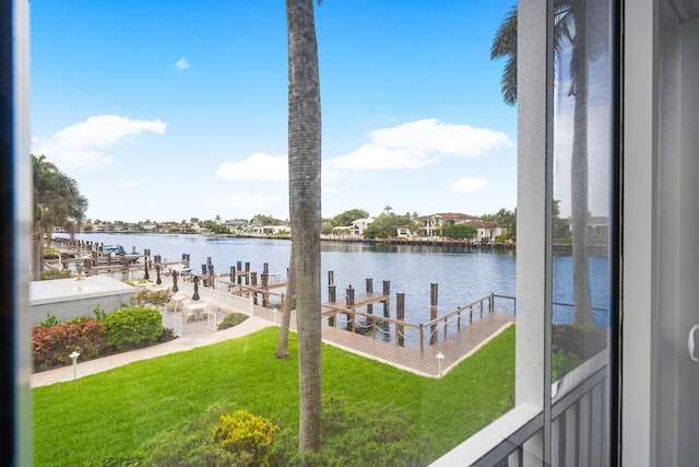 view of dock with a water view and a yard