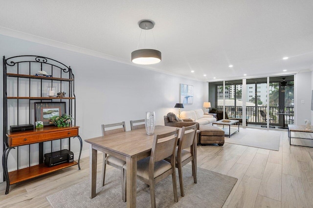 dining area featuring light hardwood / wood-style floors, expansive windows, and ornamental molding