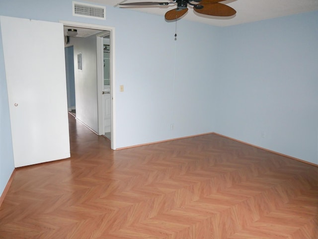 unfurnished room with ceiling fan and light parquet floors