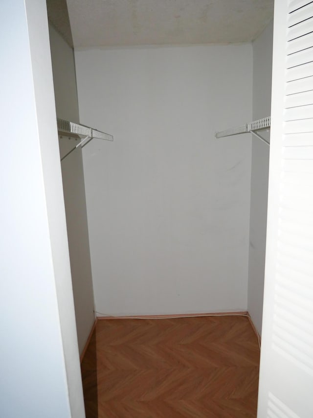 spacious closet with parquet flooring