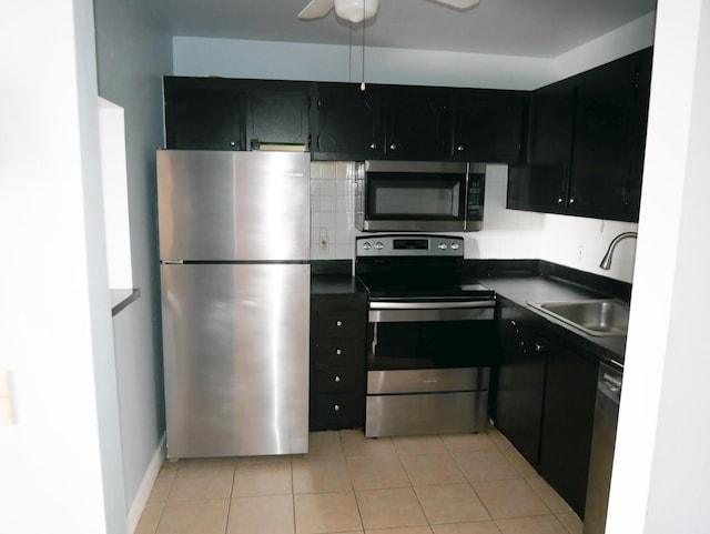 kitchen featuring appliances with stainless steel finishes, light tile patterned floors, ceiling fan, and sink