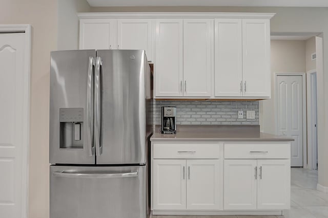 kitchen with white cabinetry, stainless steel fridge with ice dispenser, tasteful backsplash, and light tile patterned flooring