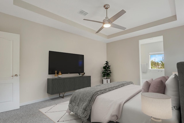 bedroom featuring light colored carpet, a raised ceiling, and ceiling fan