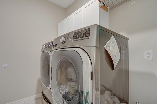 laundry area with cabinets and washer and clothes dryer