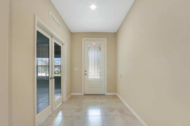 entryway featuring light tile patterned floors and french doors