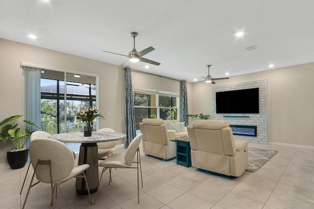 living room with a fireplace, plenty of natural light, and ceiling fan