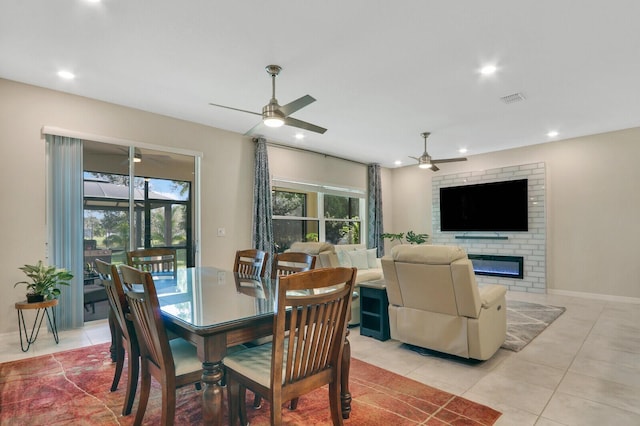 tiled dining room with a fireplace and plenty of natural light