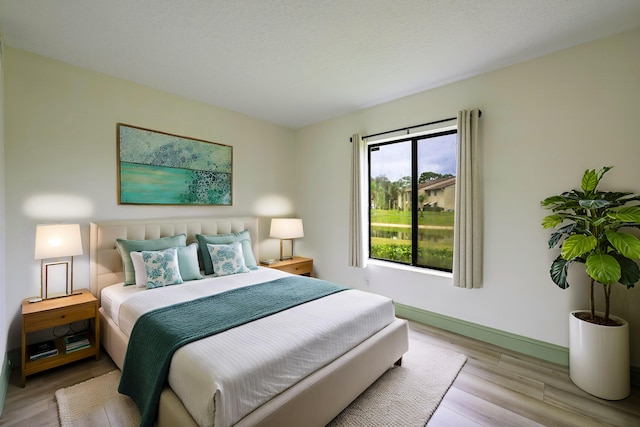 bedroom with a textured ceiling and light hardwood / wood-style floors