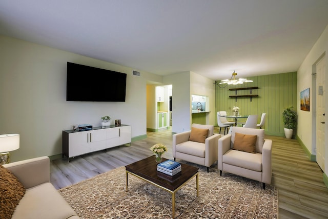 living room with hardwood / wood-style flooring and an inviting chandelier