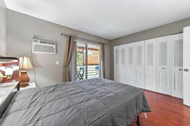 bedroom with access to outside, an AC wall unit, a closet, and wood finished floors