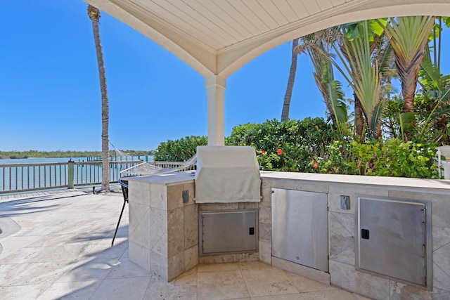 view of patio with a water view and area for grilling