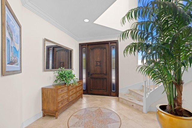 foyer entrance with crown molding and light tile patterned flooring