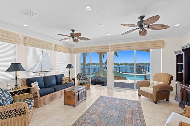 tiled living room with crown molding, a water view, and ceiling fan