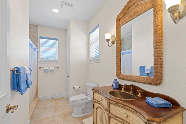 bathroom with tile patterned flooring, vanity, and toilet