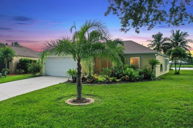 single story home featuring a garage and a lawn