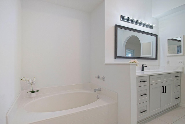 bathroom featuring tiled tub, tile patterned flooring, and vanity