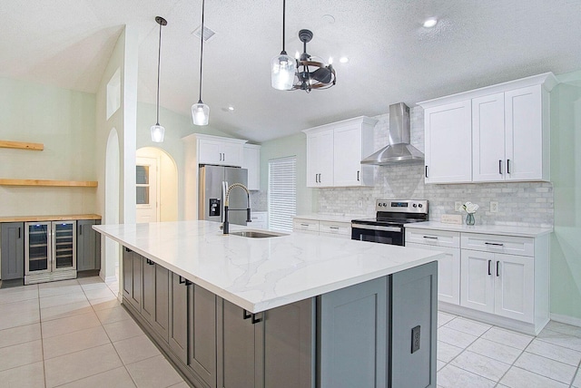 kitchen featuring white cabinetry, sink, wall chimney range hood, and appliances with stainless steel finishes