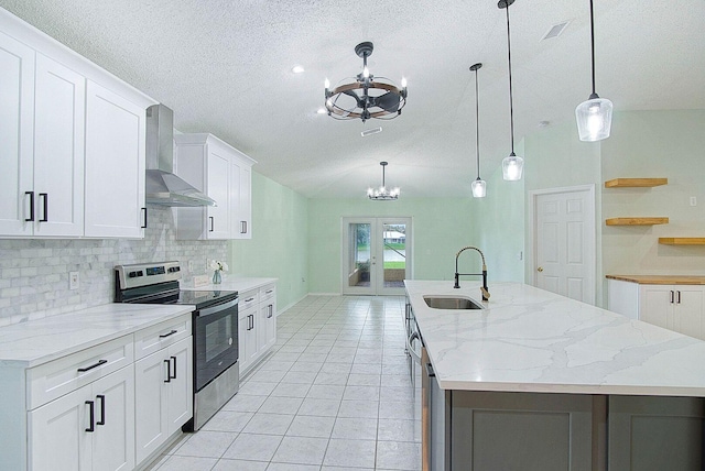 kitchen featuring white cabinets, sink, wall chimney exhaust hood, stainless steel electric range oven, and decorative light fixtures