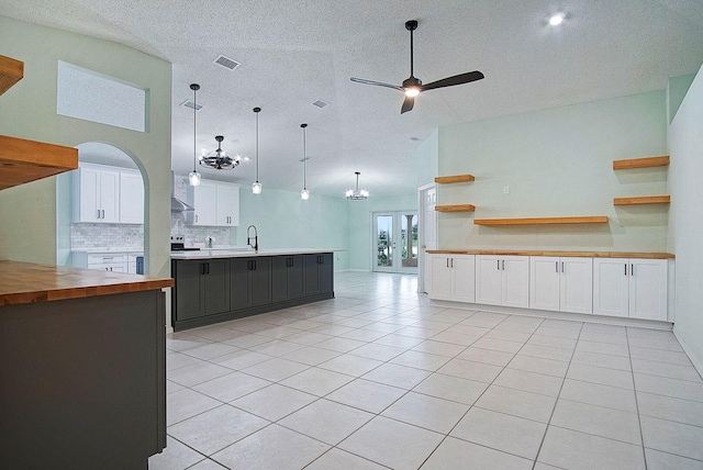 kitchen featuring tasteful backsplash, butcher block counters, white cabinetry, and pendant lighting