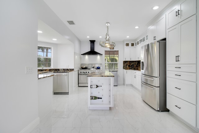 kitchen with visible vents, a kitchen island, decorative backsplash, appliances with stainless steel finishes, and wall chimney exhaust hood